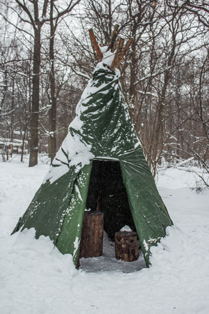 Tourist tent set in a winter snowy field.