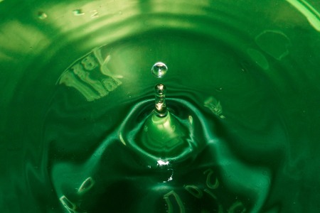 Misted glass, green rain drops dew drops on colorful abstract cool color background condensation on tinted vibrant glass windowの写真素材