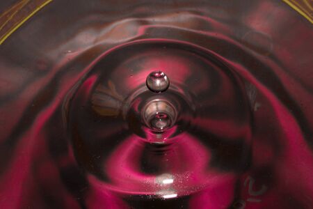 Misted glass, red rain drops dew drops on colorful abstract cool color background condensation on tinted vibrant glass windowの写真素材