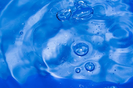Misted glass, blue and purple rain drops dew drops on colorful abstract cool color background condensation on tinted vibrant glass windowの写真素材