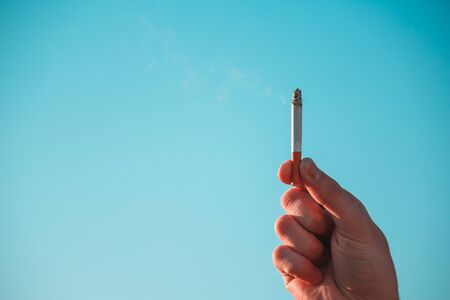 Hand Hold Cigarette with Smoke as the Cloud Idea Inspiration for World Campaign.の写真素材