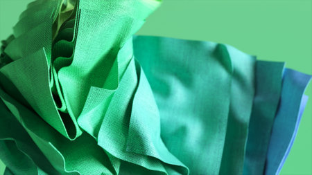 Fashion concept. Abstract background with fluttering drapery, flying folded square pieces of fabric. Green blue color.の写真素材