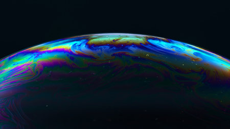 Abstract concept. The multi-colored iris of a soap bubble is in motion. Rainbow soap bubble on a...