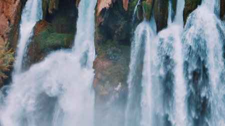 White foamy waterfall flows from the cliff. Close-up drone view. The power of the elements. Reserve....