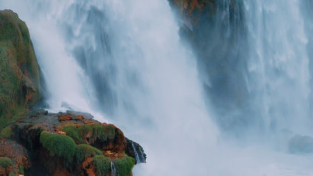 Waterfall from a cliff close-up. Aerial drone view. A stormy stream of water falls down. Nature...