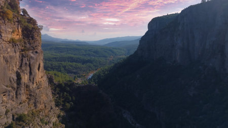 Aerial drone view of a large deep canyon. Sheer cliffs and green trees. Wildlife concept. Sunset background. Mountain river. High quality photoの写真素材