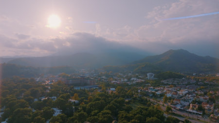 Human and nature concept. Aerial drone view of small town at the foot of the mountain. Green trees. Mountain landscape. High quality photoの写真素材