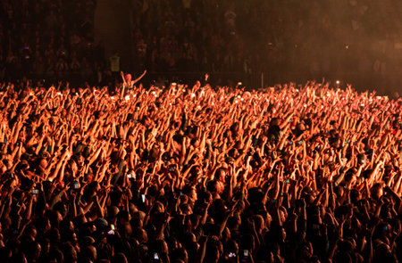 Crowd at a concert with hands up. Side viewの写真素材