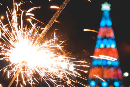 Bengal fire in hand, sparkling and colorful Christmas bokeh, new year.の写真素材