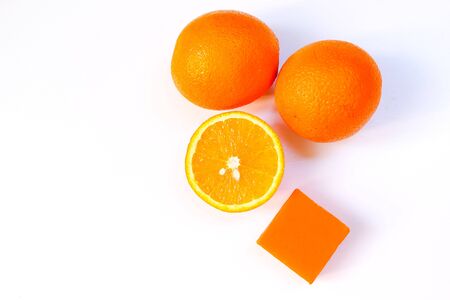 Melt and pour natural orange glycerin soap with fresh navel oranges isolated on white background.の写真素材