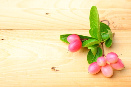 Fresh carissa carandas fruits on wooden background with copy space.