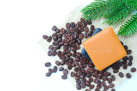 Charcoal and coffee soap bars on white background decorated with roasted coffee beans and green pines.の写真素材