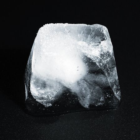 Ice Cube on black reflective background with Water Drops