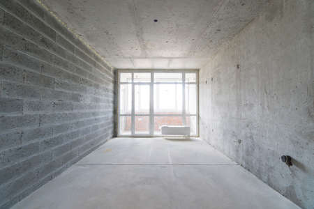 interior of the apartment without decoration in gray colors with a windowの写真素材