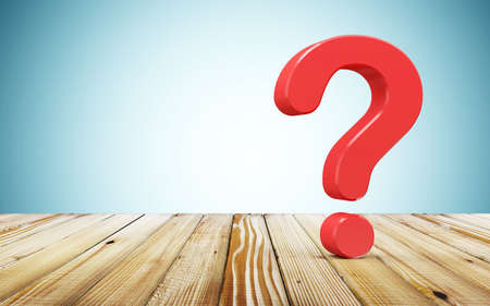 Red question mark on wooden table over blue background. 3D Renderingの写真素材