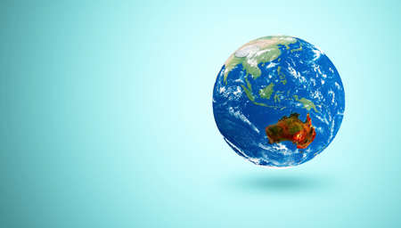 Earth Globe Miniature on turquoise background. Australia in Fire. The continent was swept by large-scale fires a natural disaster. 3D Renderingの写真素材