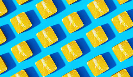 Creative pattern made of yellow slices on blue background. Minimal summer concept.の写真素材