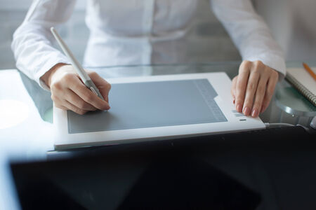 Woman`s hand drawing with a graphics pad and notebookの写真素材