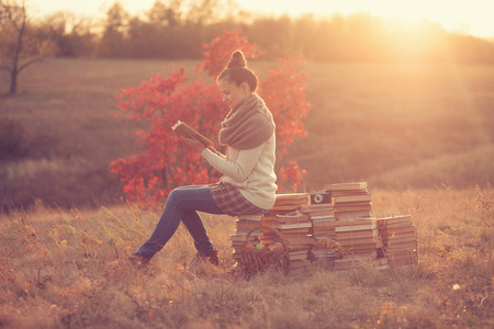 Hipster girl reading at sunsetの写真素材