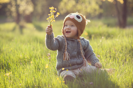 Cute baby in knitwears playing at the gardenの写真素材