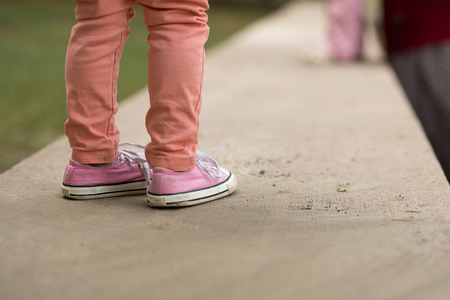 Close Up of kids sneakers walking on streetの写真素材