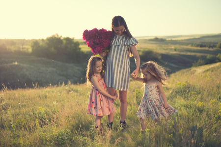 family portrait of mother with two daughters during nature strollの写真素材