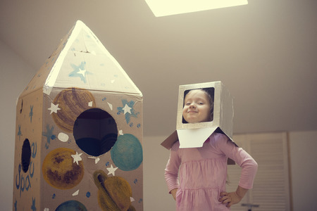 Little astronaut ready to travel to the stars. Playing with spaceship
