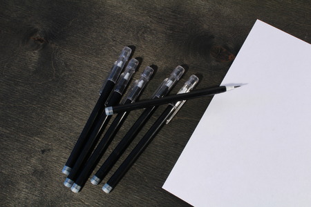 Paper and pencils on the black wooden tableの写真素材