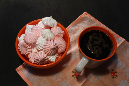 Meringue Cookies with nuts and cup of coffee on dark wooden background, top viewの写真素材