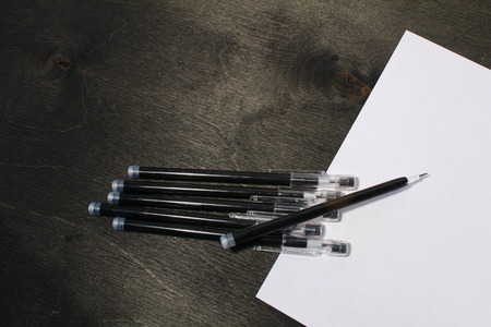 Paper and pencils on the black wooden tableの写真素材
