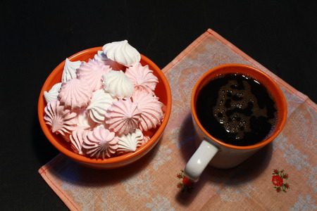 Meringue Cookies with nuts and cup of coffee on dark wooden background, top viewの写真素材