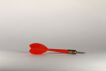 a red plastic dart arrow with white backgroundの写真素材