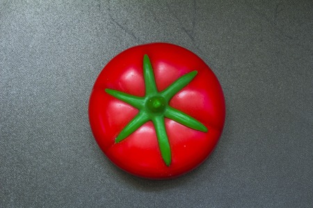 lid a stylization of kitchen jar two red tomatoes close-up on black backgroundの写真素材