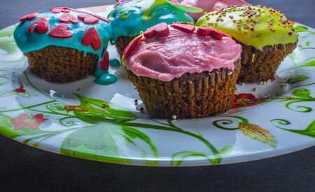 Cupcakes with sweet color cream on black background