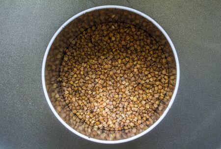 buckwheat in metal tin close-up on black backgroundの写真素材