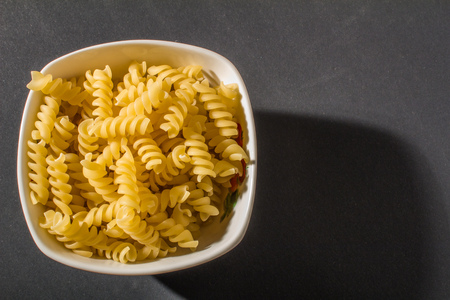 macaroni pasta in plate on black backgroundの写真素材