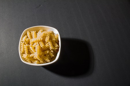 macaroni pasta in plate on black backgroundの写真素材