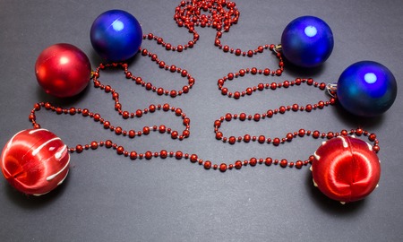 Christmas red and blue balls with bead on black background.