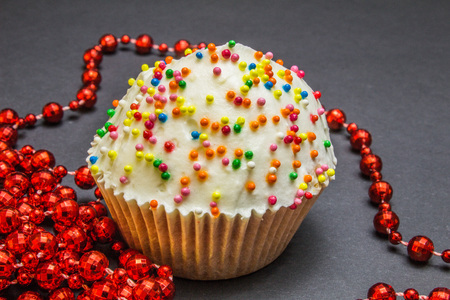 Colorful sweet cupcake with cream on black backgroundの写真素材