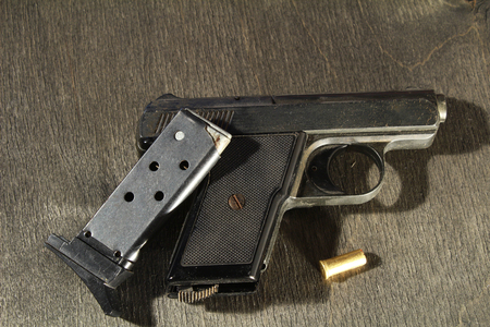 metal handgun with ammo on black wooden backgroundの写真素材