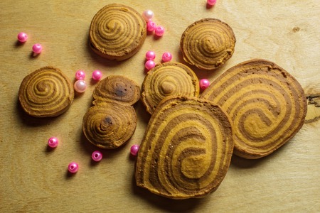 homemade cookies spiral with beads on a light wooden backgroundの写真素材