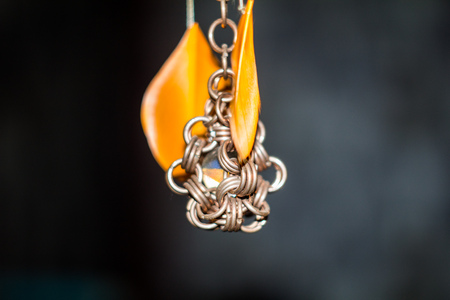 glass ball encased in a steel ring with orange feathersの写真素材