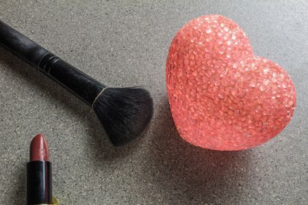 lipstick,pink heart and make-up brush on gray backgroundの写真素材
