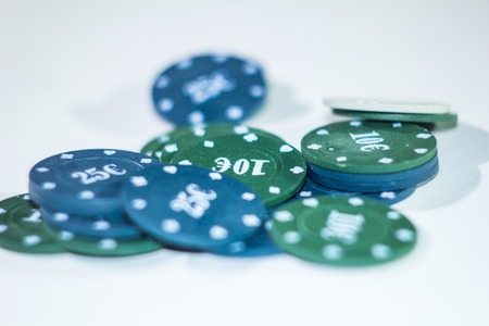 Green and blue chips for poker on a white backgroundの写真素材
