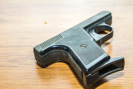 black handgun on wooden background