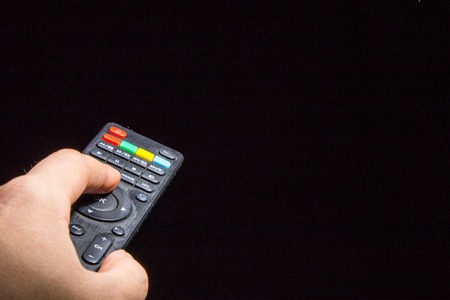 Remote Control in a hand. on black background