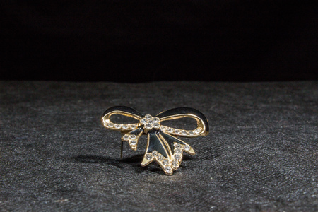 Brooch in the shape of a bow on a black backgroundの写真素材