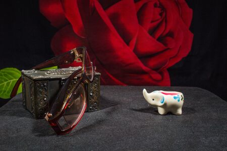 Old chest with glasses and a candle-elephant on a dark backgroundの写真素材