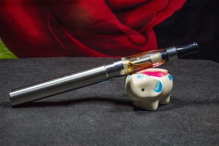 Electronic cigarette with a candle-elephant on a dark background