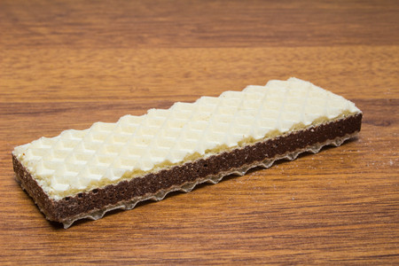 Wafer biscuits with chocolate cream on wooden background